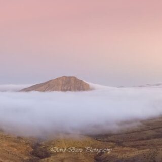 Fotografía de Tindaya amaneciendo sobre nubes en Tindaya por David Báez